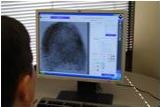 Detective analyzing a fingerprint on a computer